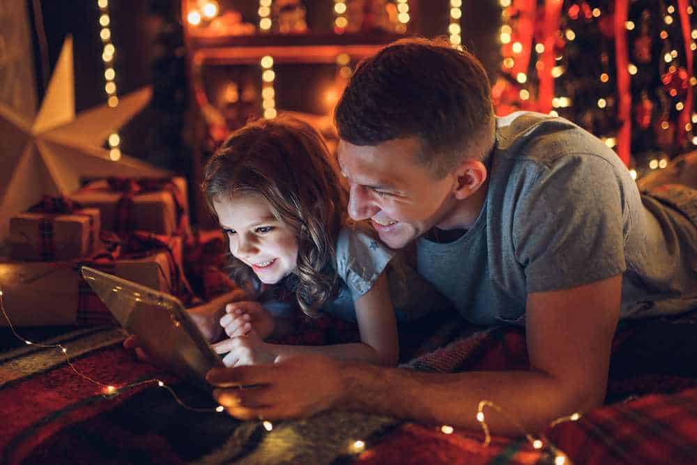 Weihnachten in der Familie - Geschichten oder Filme auf dem Tablet schauen (de.depositphotos.com)