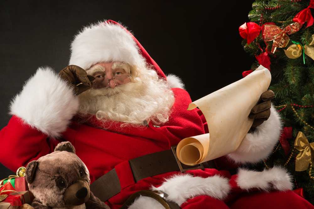 Weihnachtsmann liest Weihnachtspost von Kindern (depositphotos.com/de)
