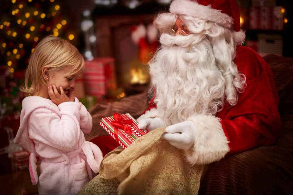 Weihnachtsmann bringt Geschenke für ein Mädchen (de.depositphotos.com)